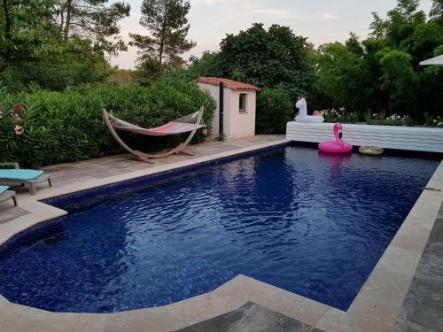 - une piscine avec un hamac et un hamac dans la cour dans l'établissement B&B Les Grillons, à Draguignan