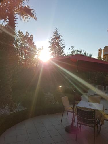 a sun shining on a table and chairs on a patio at Villa Jelena in Zadar