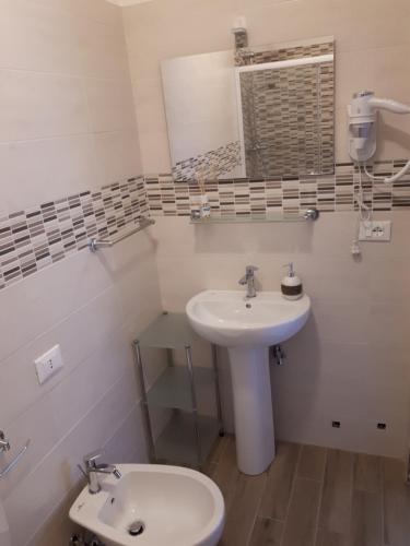 a bathroom with a sink and a toilet and a mirror at Le camere di Sabrina con bagno in camera in Sarzana