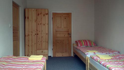 2 camas individuales en una habitación con puerta en apartmány Gingo, en Vrbno pod Pradědem