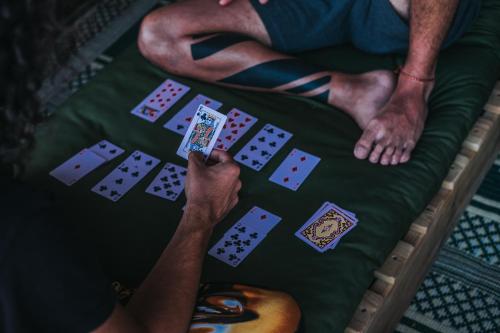 two men sitting on a bed playing cards and playing poker at Ein Gedi Camp Lodge in Ein Gedi