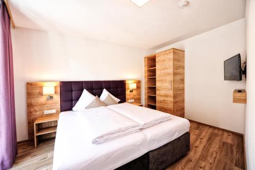 ein Schlafzimmer mit einem großen Bett mit weißer Bettwäsche in der Unterkunft Amaris Apartments in Ischgl