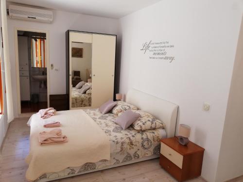 1 dormitorio con cama y espejo grande en M & J Central Suites, en Korčula