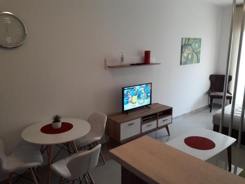 a living room with a tv and a table and chairs at Apartman Nina in Bar