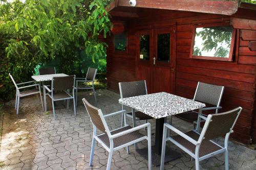 a group of tables and chairs on a patio at Marben Panzió in Hegykő