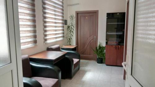 a waiting room with two tables and a door at Sheki Guest House in Sheki