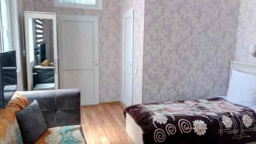 a bedroom with a bed and a chair and a mirror at Sheki Guest House in Sheki