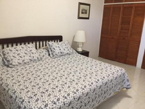 a bedroom with a bed and a lamp and a door at Hastings Towers 3B Opp Sea 2 Bed 2 Bath in Bridgetown