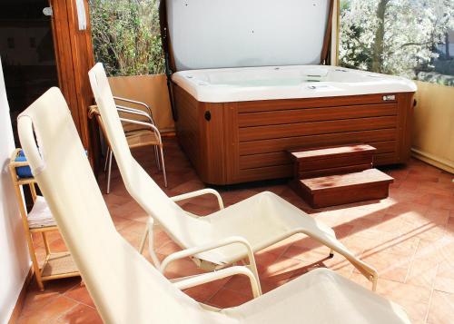 a group of chairs sitting in a room with a tub at Marben Panzió in Hegykő