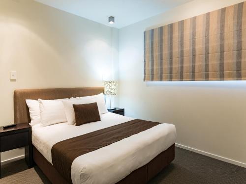 a bedroom with a bed and a window at Sea Spray Suites in Paihia