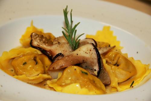 a white plate of food with pasta and meat at Delfina Palace Hotel in Foligno