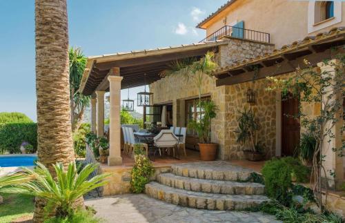 a house with a patio with a table and chairs at Font in Mancor del Valle