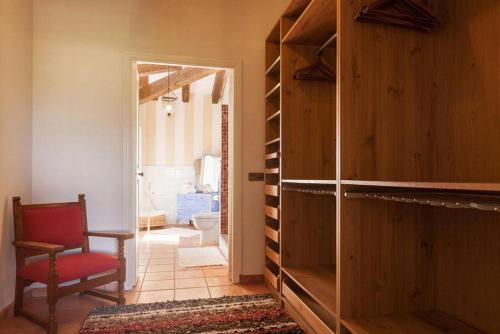 a room with a door leading into a room with a red chair at Font in Mancor del Valle