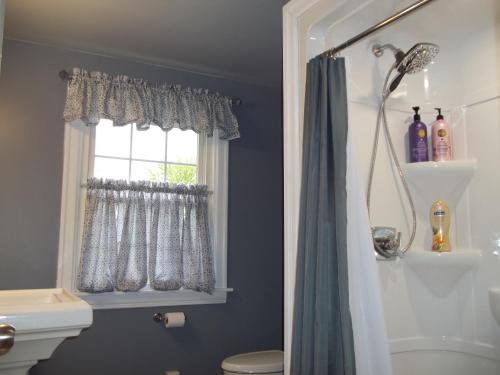 a bathroom with a shower curtain and a window at Abide Within Bed & Breakfast in Truro