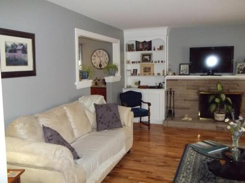 a living room with a white couch and a fireplace at Abide Within Bed & Breakfast in Truro