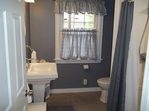 baño con lavabo y aseo y ventana en Abide Within Bed & Breakfast, en Truro