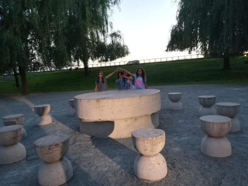 two girls sitting on a stone bench in a park at Casa Lipianu in Târgu Jiu
