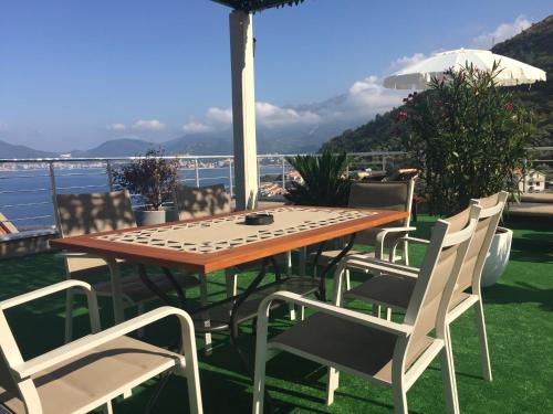 a wooden table and chairs with a view of the water at Guest house Villa Slavica in Sveti Stefan