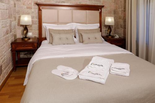 a bedroom with a bed with two towels on it at YundAntik Cunda Konaklari in Ayvalık