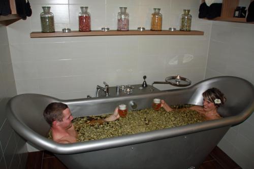a man and woman sitting in a bath tub at Hotel Bílý jednorožec in Třeboň