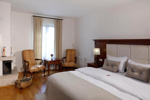 a bedroom with a large bed and a fireplace at YundAntik Cunda Konaklari in Ayvalık