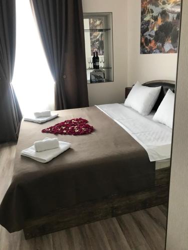 a bedroom with a large bed with towels on it at Sweet Rooms Inn in Tbilisi City