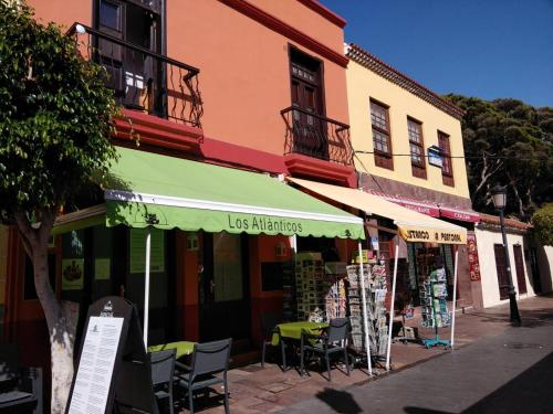 a store with tables and chairs in front of a building at Apartamento La Peatonal in San Sebastián de la Gomera