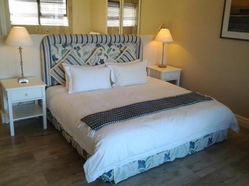 een slaapkamer met een groot bed met 2 nachtkastjes bij Our Beach House in Southbroom