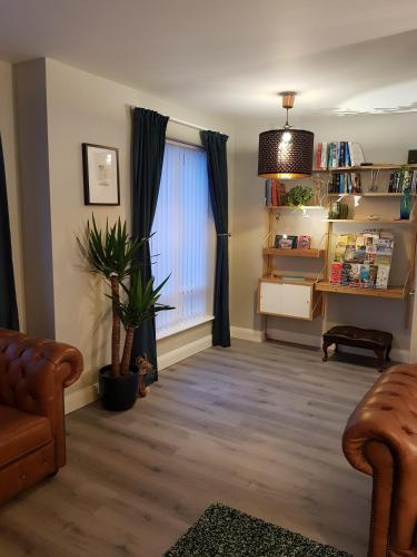 a living room with a couch and a window at Spire View Townhouse in Ballycastle