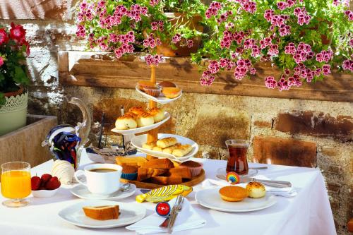 a table with breakfast foods and coffee on it at YundAntik Cunda Konaklari in Ayvalık