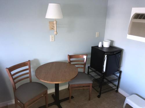 a room with a table and two chairs and a desk at Surfside Motel in Point Pleasant Beach