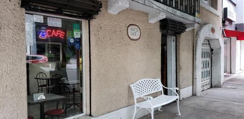 une chaise blanche placée devant une vitrine de magasin dans l'établissement Anys Hostal, à Mexico