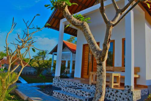 ペニダ島にあるWahyu Masari Homestayの前に木がある家