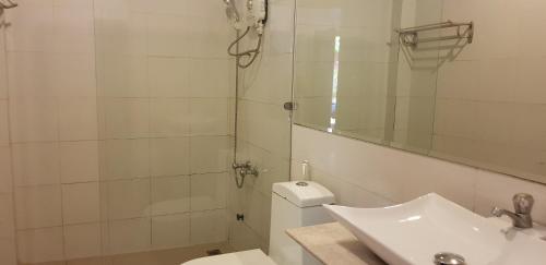 a bathroom with a sink and a toilet and a mirror at Apex Koh Kong Hotel in Koh Kong