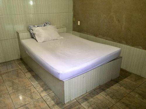 a bed in a room with a white mattress at Kitnet BH in Belo Horizonte
