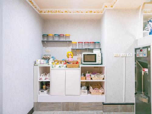 a toy kitchen with a refrigerator and a microwave at Gwawa Hotel in Kaohsiung