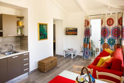 uma cozinha e uma sala de estar com um sofá vermelho em Regginè Holiday Apartments em Sant'Agnello