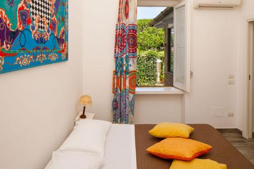 1 dormitorio con cama, mesa y ventana en Regginè Holiday Apartments en Sant'Agnello