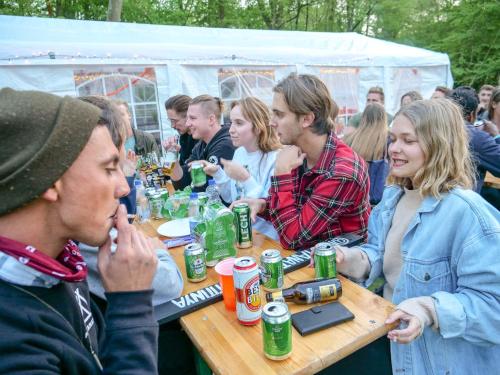 un groupe de personnes assises à une table avec des boissons dans l'établissement Festanation Oktoberfest Camp #1, à Munich