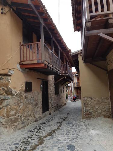 an alley with a balcony on the side of a building at Irene's House in Kakopetria