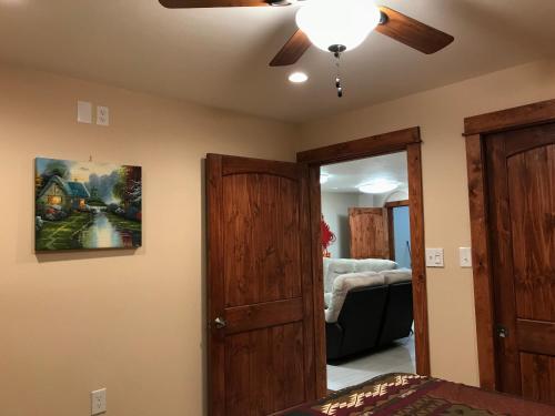 a living room with a ceiling fan and a bedroom at Delta Dome Home Basement Apartment in Delta Junction