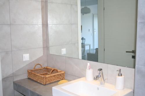 ein Bad mit einem Waschbecken und einem Spiegel in der Unterkunft Thalassa Apartment in Kallirákhi