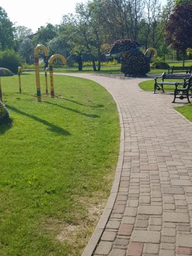 a brick path in a park with benches at Holiday Home Ermine in Sigulda