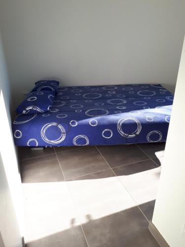 - un lit avec une couette bleue dans l'établissement le cube cassiopée, au Cap d'Agde