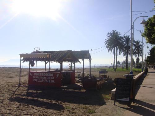 a food stand on a beach with palm trees at Apartamentos casa Tia Antonia in Málaga