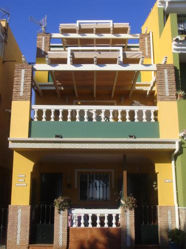 a yellow and green building with a balcony at Apartamentos casa Tia Antonia in Málaga