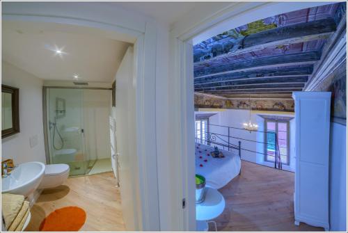 a room with a bed and a bathroom with a ceiling at VILLA VINICIA, pool, jacuzzi, airco in Domaso