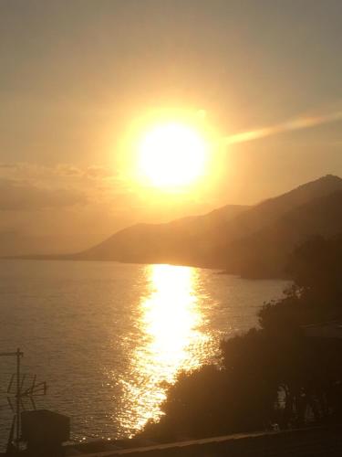 a sunset over the water with the sun in the sky at B&B Casetta del Marinaio in Camogli