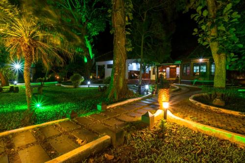 a garden at night with a light in the middle at Warmth Lake Haven in Alleppey