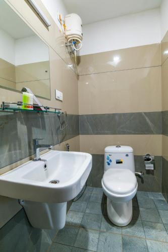 a bathroom with a white toilet and a sink at Warmth Lake Haven in Alleppey